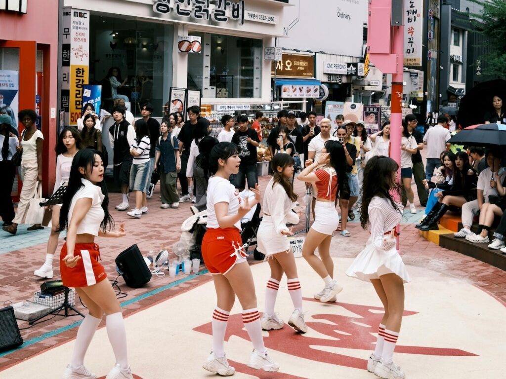 A professional K-pop dance cover team performing for a crowd at Hongdae Red Road, one of the top K-pop Dance Locations in Korea for 2026.
