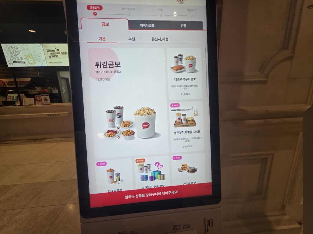 lotte-cinema-jamsil-ordering-kiosk-menu-options A close-up of a Lotte Cinema Jamsil ordering kiosk screen displaying the extensive combo menu and character merchandise for efficient pre-show procurement.