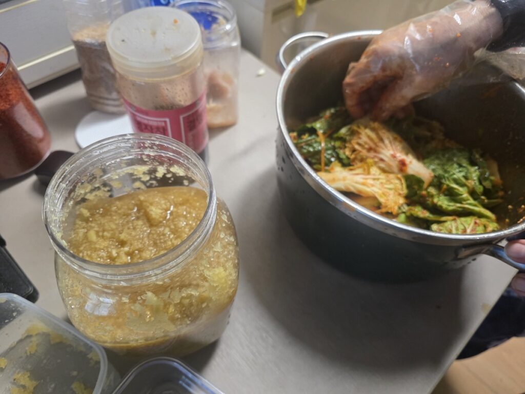 Preparing Geotjeori (Fresh Kimchi Salad) with a large amount of fresh minced garlic, a key ingredient for high antioxidant levels in a healthy Korean diet.