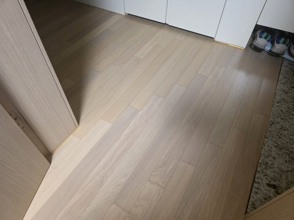 The clean wooden floor of a modern Korean apartment, designed for both comfort and traditional seating.