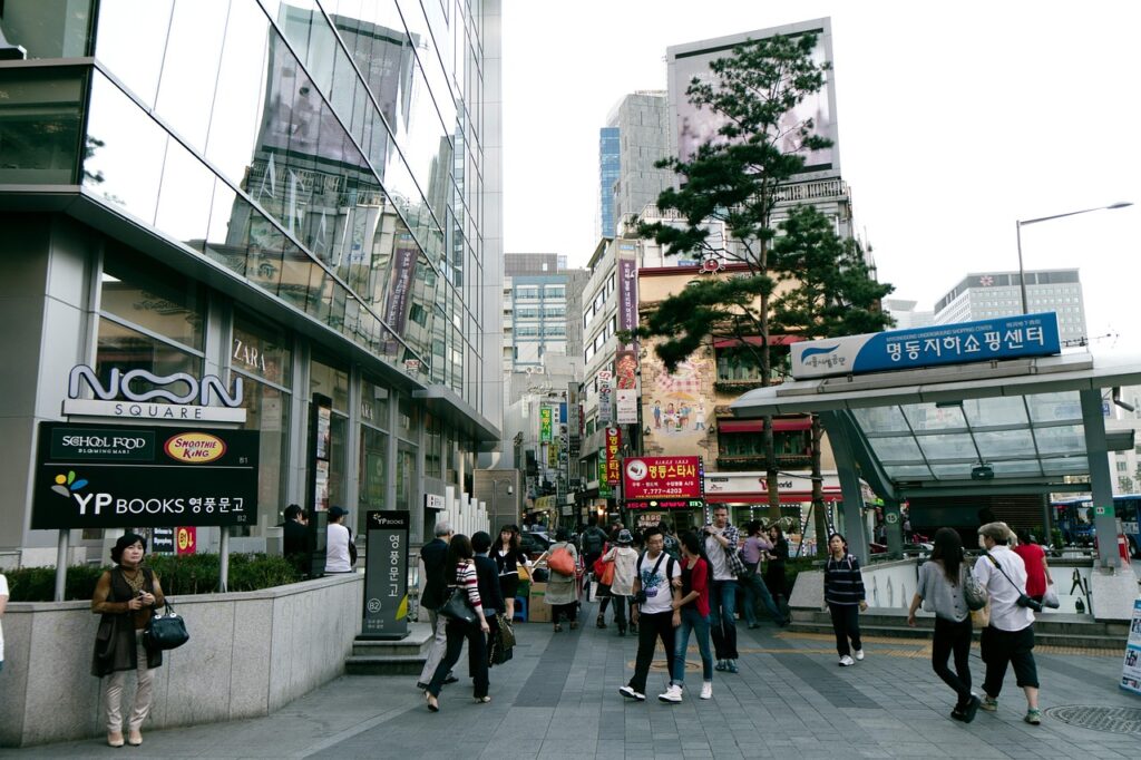 "Inside Myeongdong Subway Station in Seoul, with travelers walking past bilingual Korean and English signs on the platform."