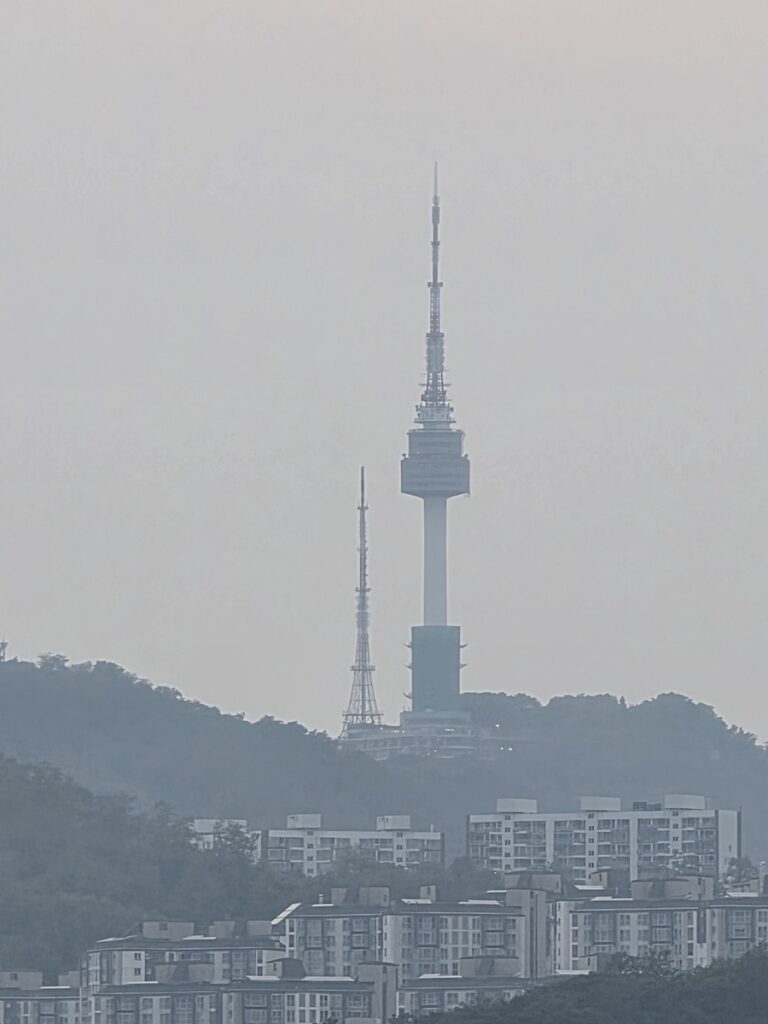 namsan-tower-seoul-cityscape “Distant view of Namsan Seoul Tower rising above the city skyline”