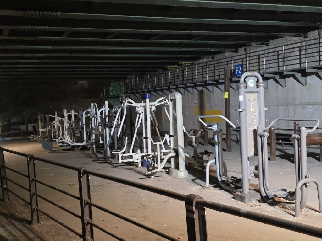 night-workout-machines-seoul Mechanical exercise machines for local residents at Han River park at night.