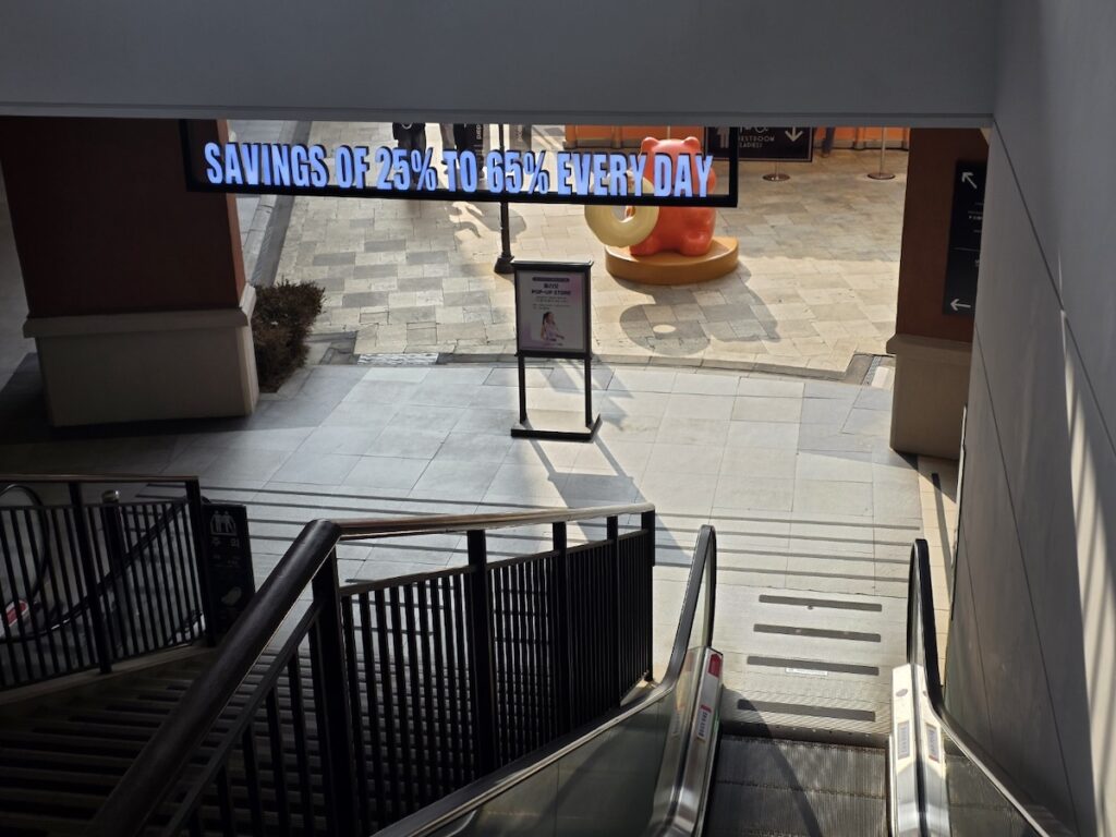 paju-outlet-savings-discount-sign A digital sign at Shinsegae Simon Premium Outlets Paju advertising savings of 25% to 65% every day, welcoming shoppers to the sanctuary of discounts.