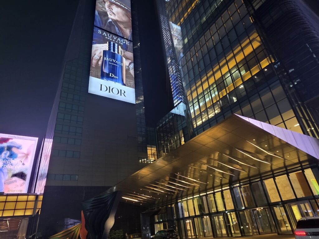 parnas-tower-luxury-dior-billboard-samseong The grand entrance of Parnas Tower at night, featuring a massive Dior Sauvage digital billboard and sleek golden architectural lighting in Gangnam, Seoul.