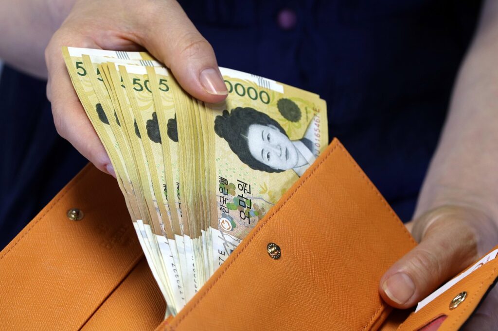 paying-bill-at-korean-restaurant-no-tip-button A customer paying the bill at a South Korean restaurant counter, showing that the credit card machine only charges the menu price with no option for tipping in South Korea.