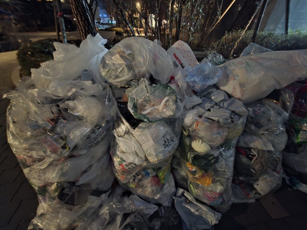 plastic-bag-recycling-in-south-korea-apartment A massive pile of transparent bags filled with plastic waste during a weekly recycling day in a South Korean apartment complex.