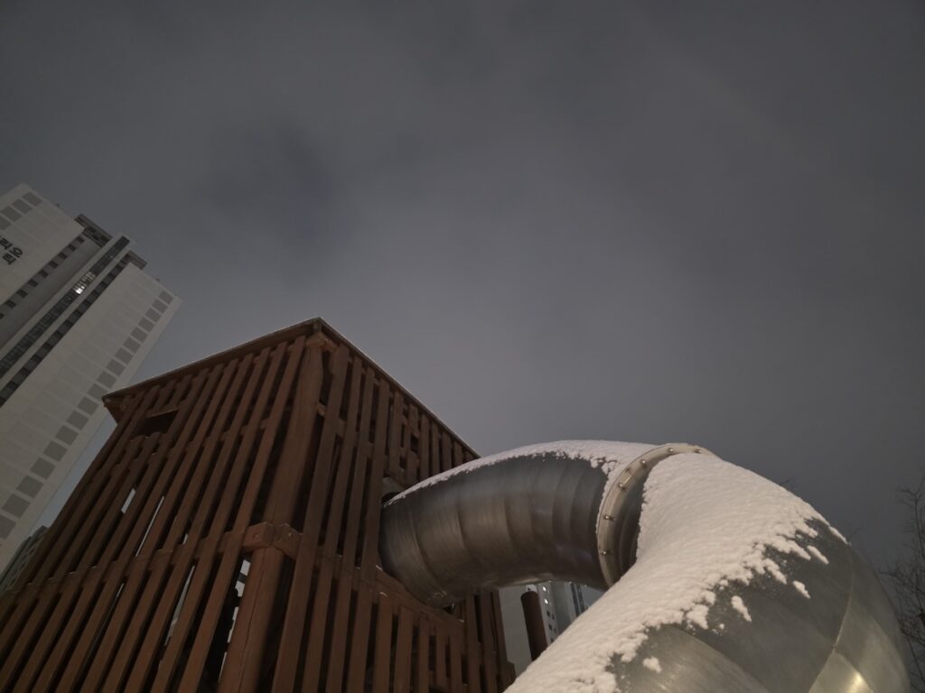 pristine-snow-playground-sanctuary A snowy playground at night, where the untouched white on the slide offers a chemical-free sanctuary for play.