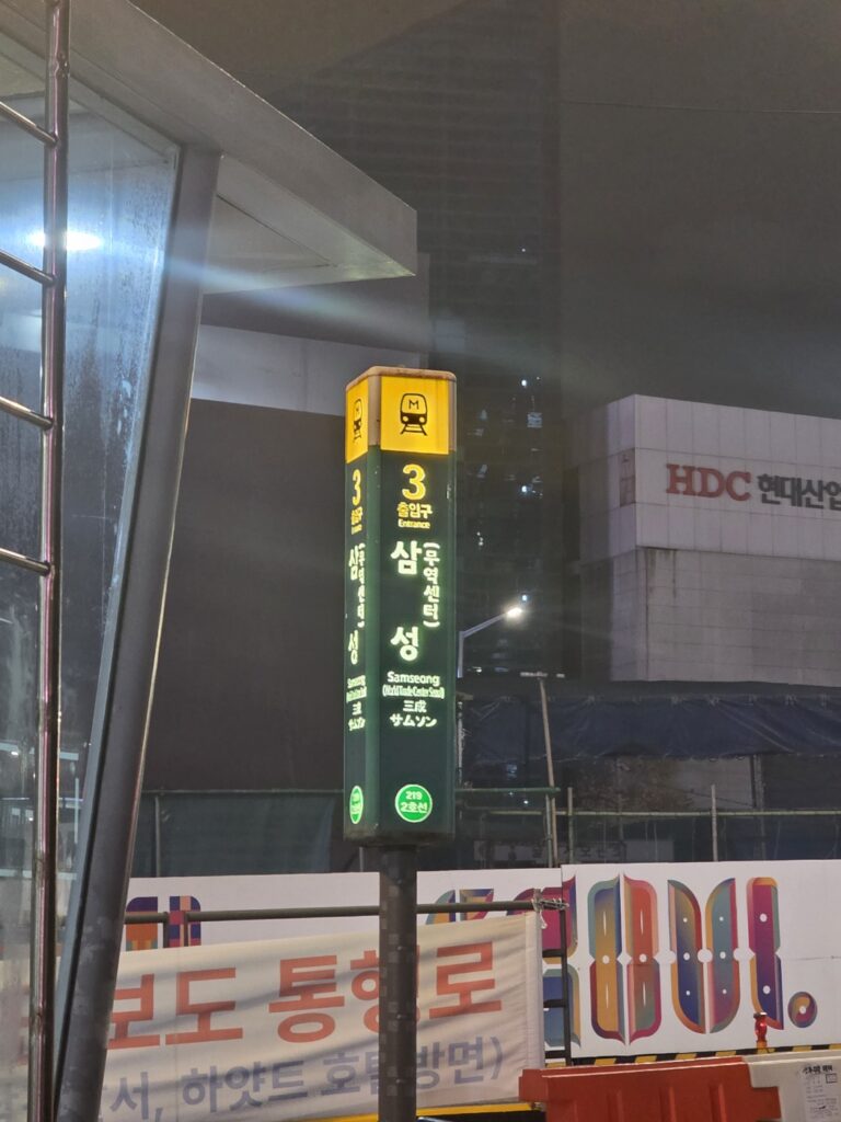 The main road outside Samseong Station, showing traffic, office towers, and Seoul’s urban layout.
