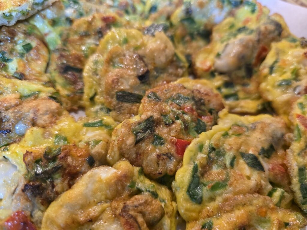 seasonal-korean-oyster-pancake-guljeon Close-up of golden brown Gul-jeon (Korean oyster pancakes), a premium winter seasonal delicacy.