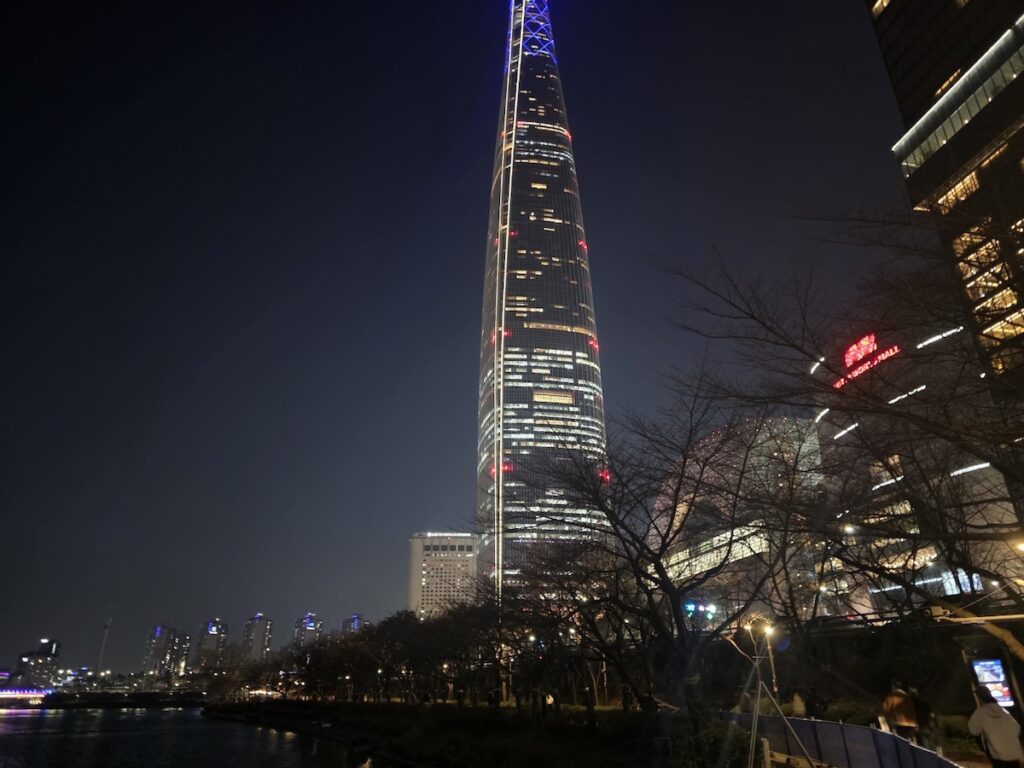 seokchon-lake-night-ritual-lotte-world-tower-skyline.jpg The iconic Lotte World Tower and Signiel Seoul rising above the trees during the **Seokchon Lake Night Ritual**.