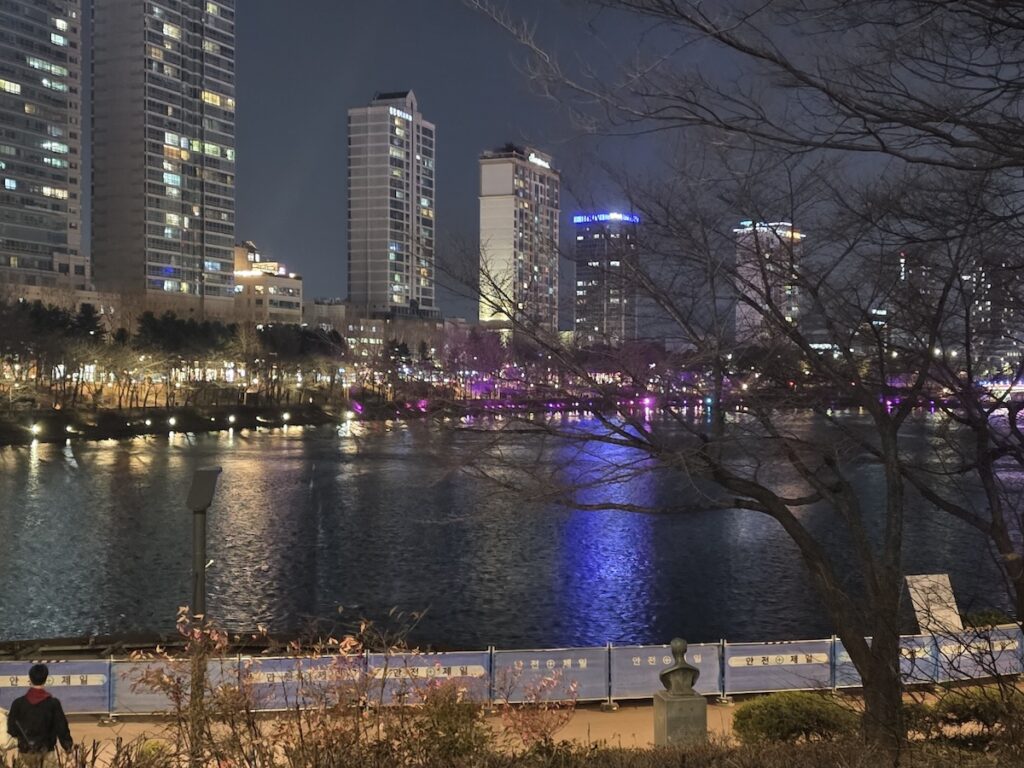 seokchon-lake-night-ritual-quiet-waterfront-serenity The serene and quiet waterfront of Seokchon Lake after dark, capturing the essence of the **Seokchon Lake Night Ritual**.