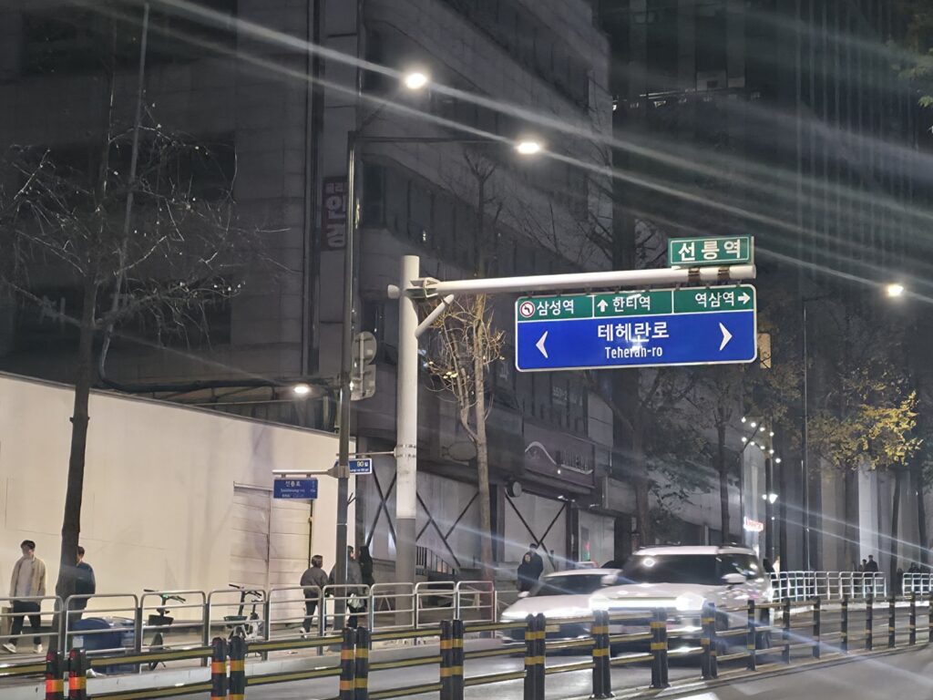 The main road outside Seolleung Station, featuring offices, traffic, and the clean urban layout of Gangnam.