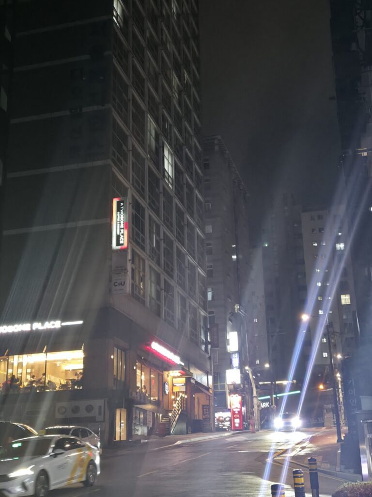 A street view near Seolleung Station in Gangnam, showing modern buildings and pedestrian sidewalks.