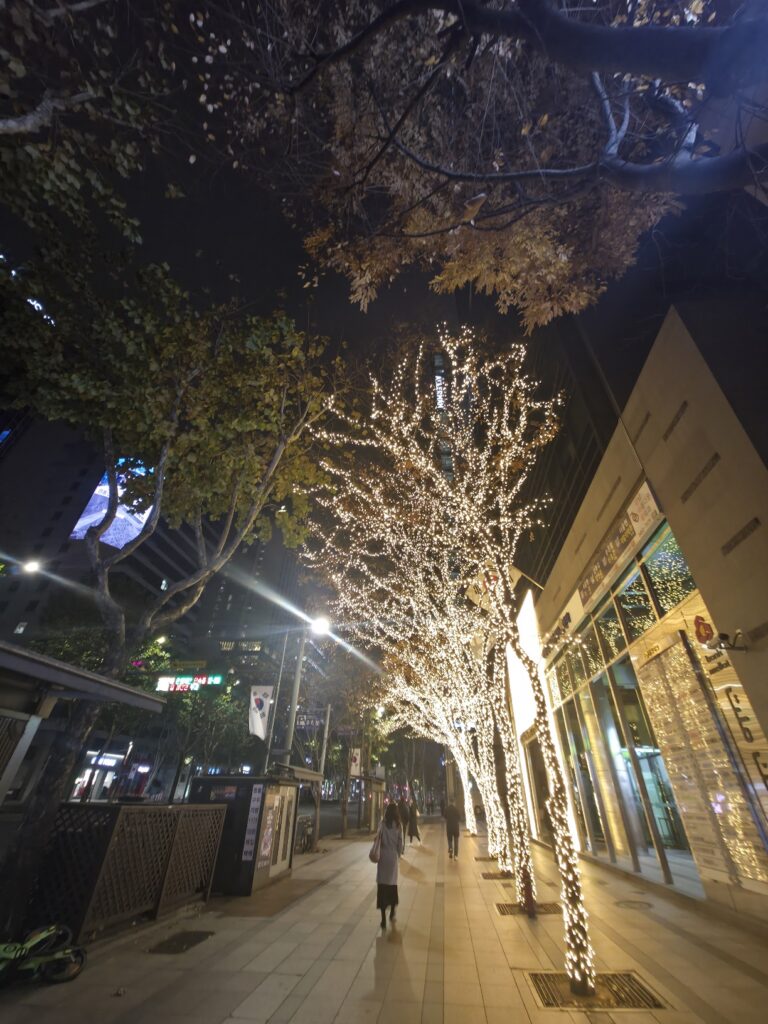 An urban view near Seolleung Station showing a mix of modern architecture, sidewalks, and everyday city life.