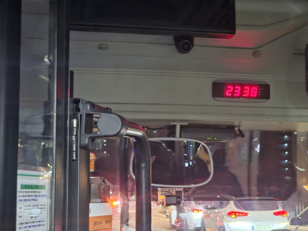 seoul-bus-last-call-time-check-2338 A digital clock inside a Seoul city bus showing 23:38, illustrating the critical time to check the Seoul subway and bus last call schedules.