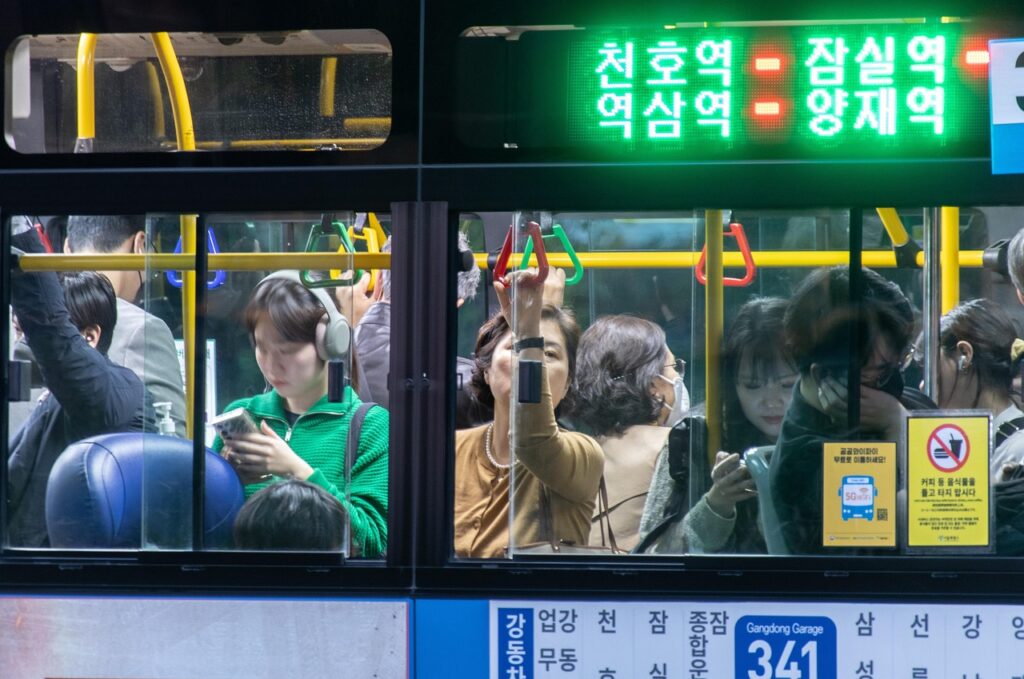 seoul-bus-transportation-system-2025 “Seoul city blue bus running through Gangnam district with passengers, highlighting the efficient public transportation system in Korea.”