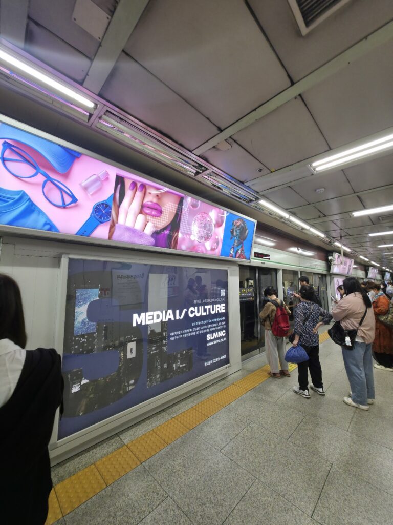 Passengers waiting on a Seoul Line 2 platform beside platform screen doors.