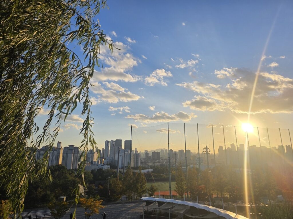 Golden sunset over the Seoul skyline viewed from a mountain trail, a perfect finale for a day of Hiking in Seoul for Foreigners.