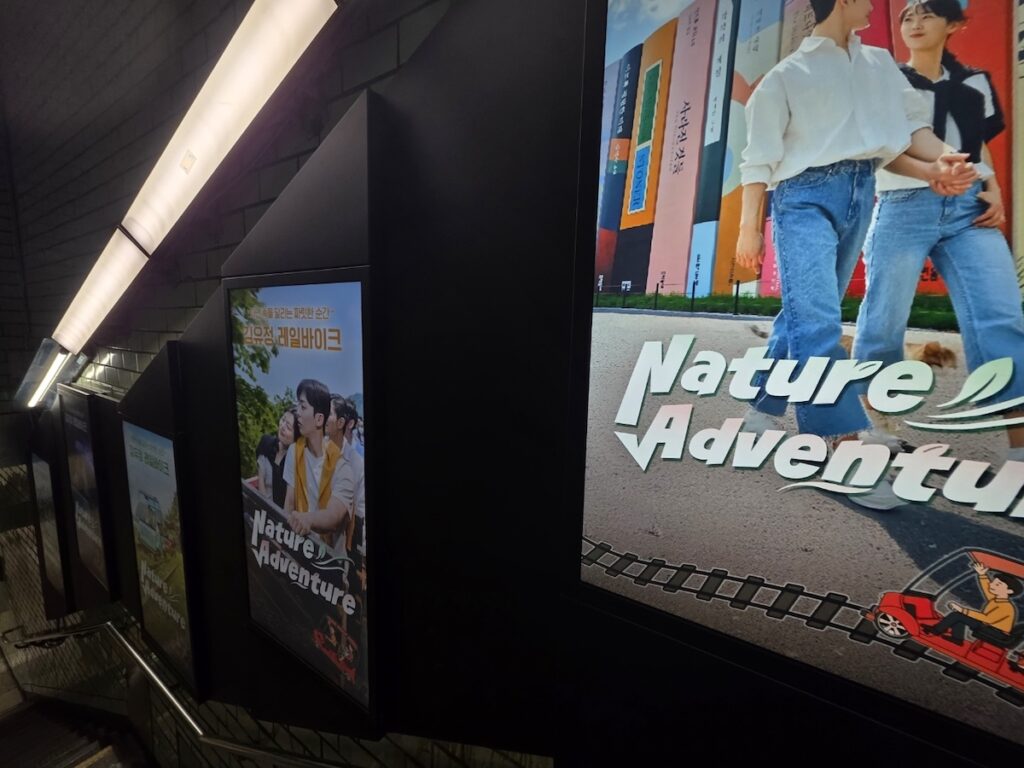 seoul-subway-digital-art-advertising Large digital advertising screens lining the subway walls, transforming the station into a vibrant gallery.