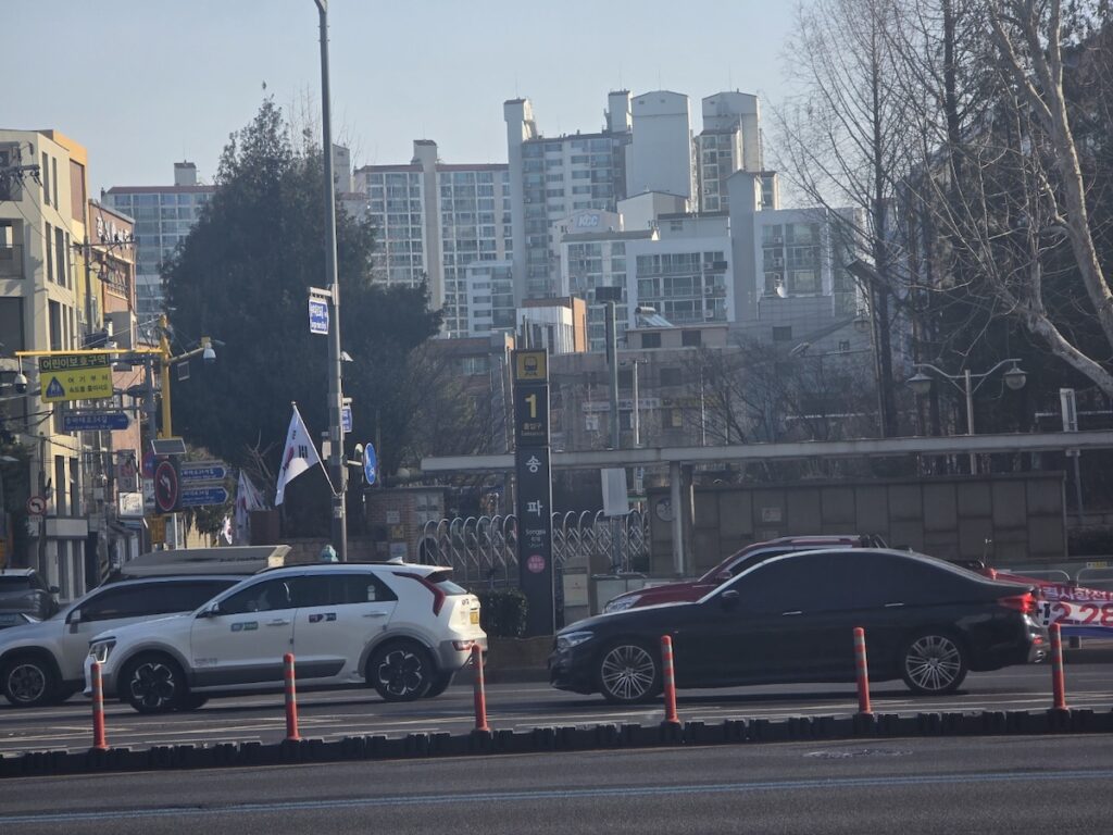 seoul-subway-exit-numbers-and-directions-songpa-exit-1-anchor Songpa Station Exit 1, the "Anchor" point of the station, surrounded by residential apartments and the South Korean flag, illustrating Seoul Subway Exit Numbers and Directions.