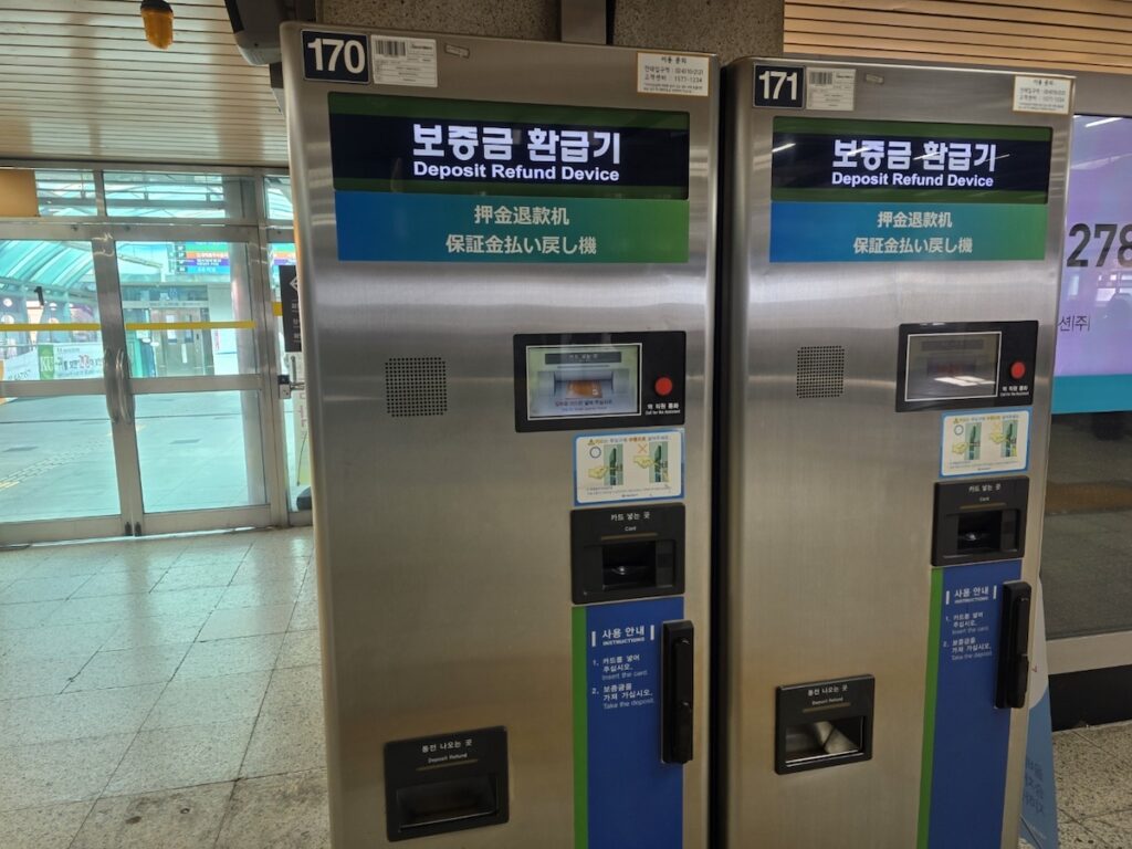seoul-subway-kiosk-guide-deposit-refund-device Two stainless steel deposit refund devices in a subway station, as described in this Seoul Subway Kiosk Guide for reclaiming ticket deposits.