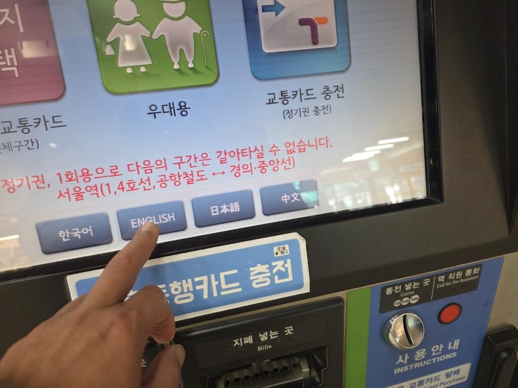 seoul-subway-kiosk-guide-english-interface A close-up view of the Seoul Subway Kiosk Guide interface, showing a user selecting the "ENGLISH" language option on a silver ticketing machine to prevent directional and fare errors.