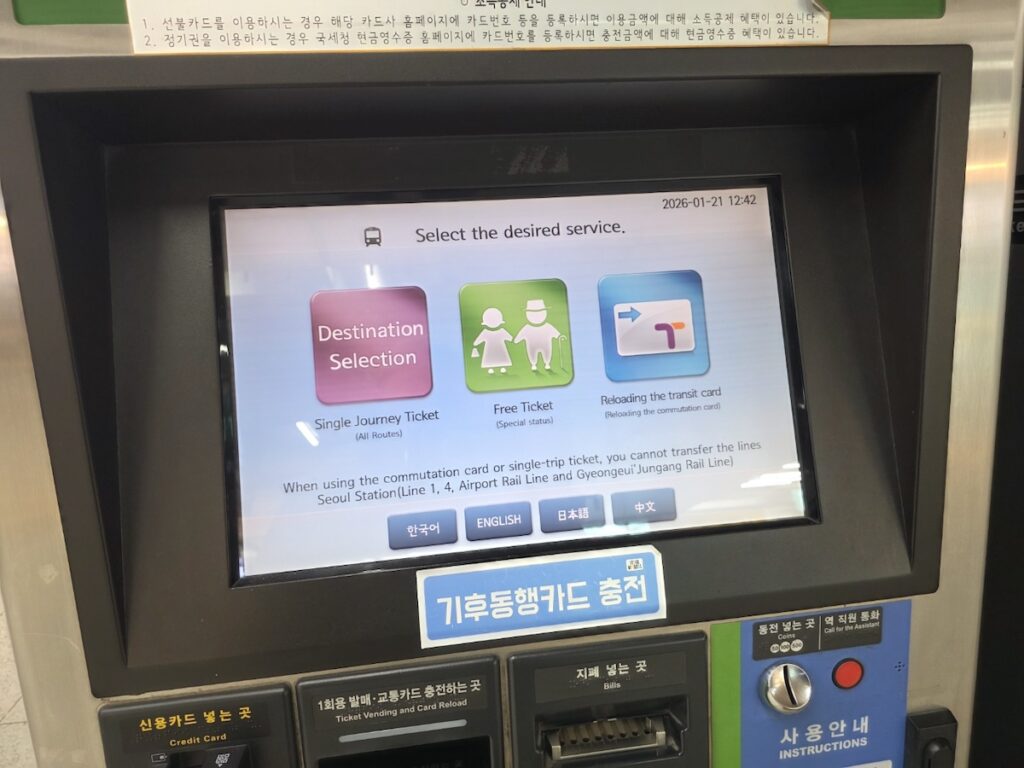 A detailed Seoul Subway Kiosk Guide showing a hand selecting the English button and highlighting critical transfer warnings in red.