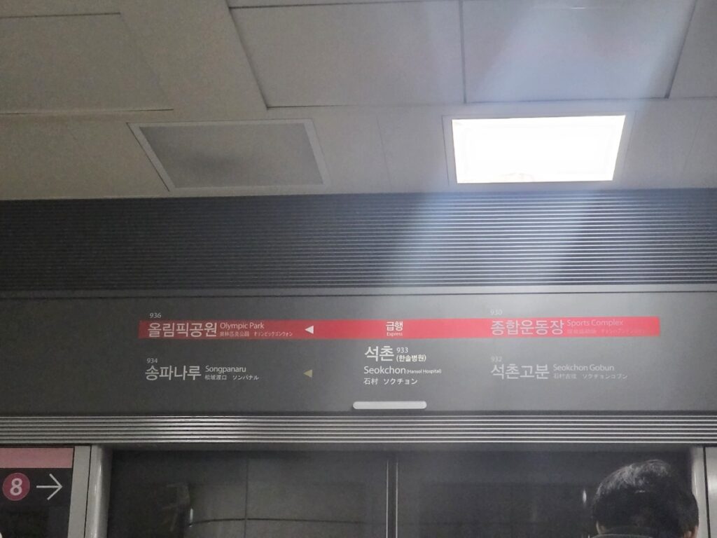 seoul-subway-line-9-express-vs-local Digital display at Seokchon station showing Express (red) and Local (green) train arrivals for Line 9