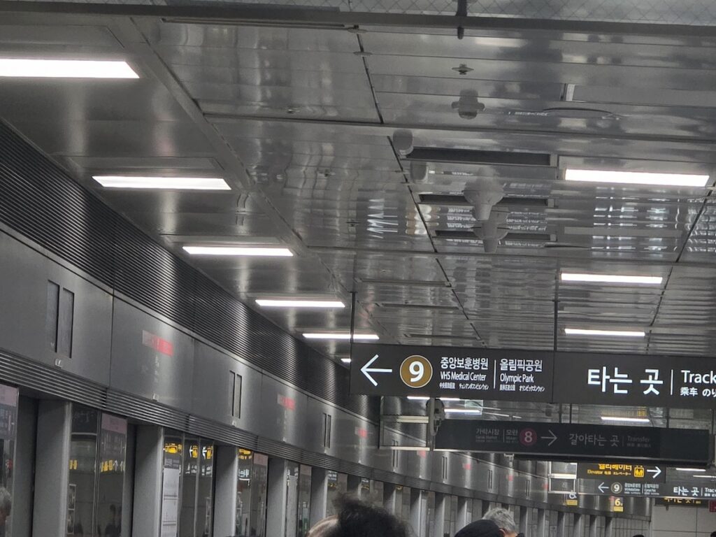 seoul-subway-line-9-transfer-sign Directional signage for Line 9 transfer at Seokchon station showing directions to Olympic Park and VHS Medical Center.