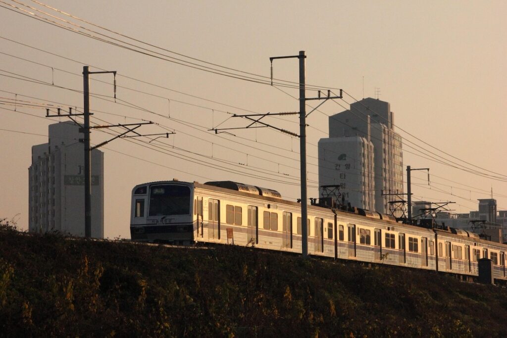 seoul-subway-morning-commute-gold Korea Travel: Budget Saving Guide - A Seoul subway train running above ground during the golden hour of the early bird ritual.