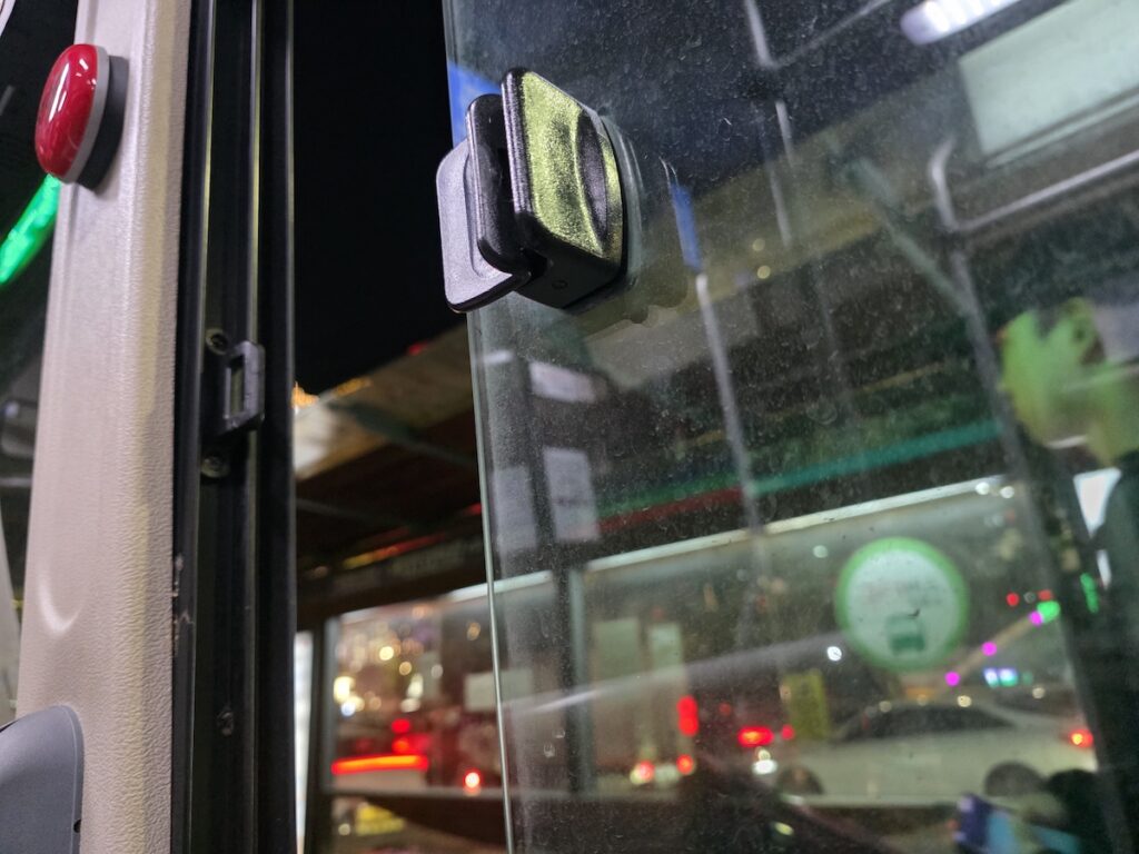 seoul-summer-travel-city-bus-night The interior of a cooled Seoul city bus at night, showing a stop button and window latch during Seoul summer travel.