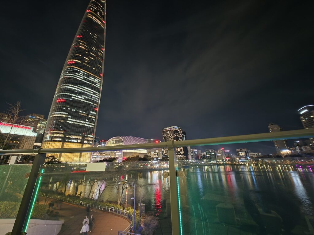 seoul-travel-mistakes-seokchon-lake-night-walk Seoul travel mistakes image showing Seokchon Lake and Lotte World Tower at night during a slower Seoul evening walk