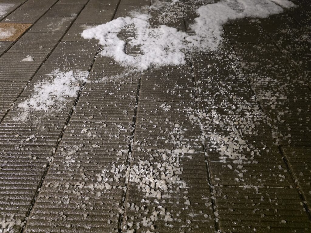 seoul-urban-winter-salt-maintenance **Snowy Seoul Survival** calcium chloride granules on sidewalk.