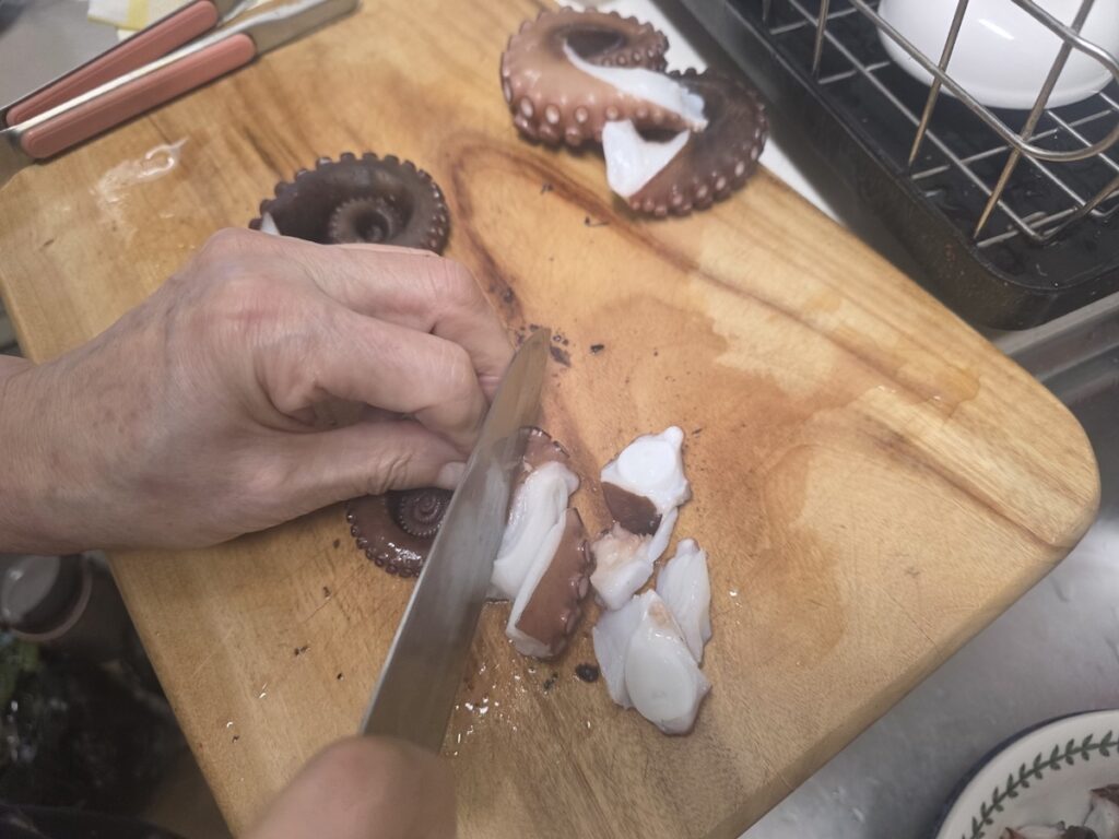 slicing-boiled-octopus-chef-skills Precision slicing of boiled octopus to ensure a Perfectly Chewy mouthfeel.