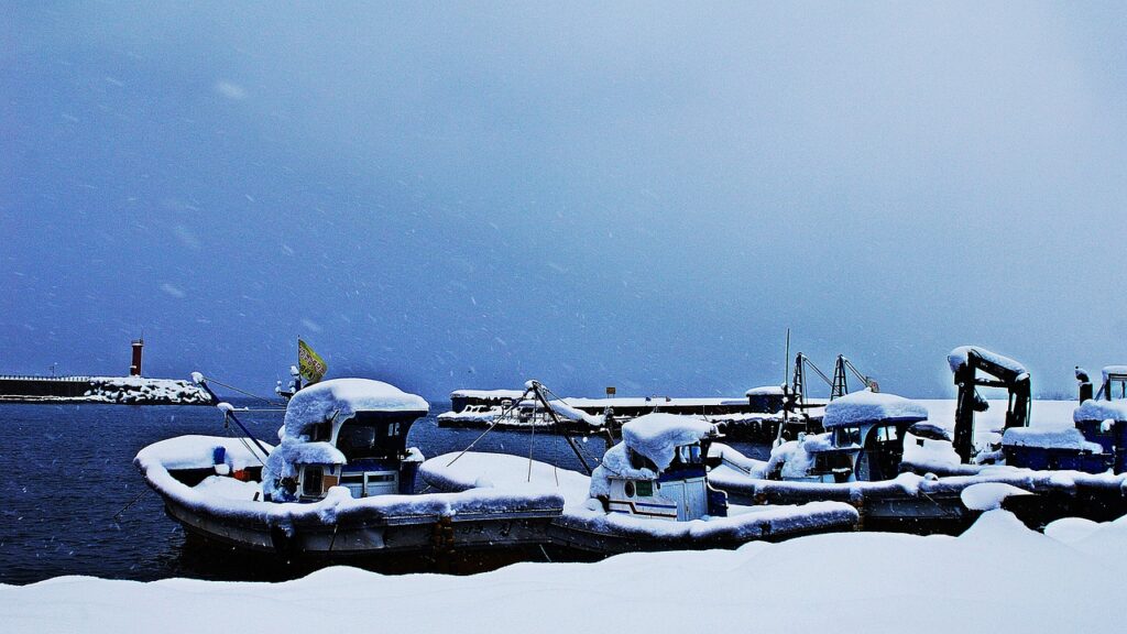 snowy-lake-boat-korean-winter-landscape A small boat resting on a frozen lake surrounded by snow, capturing the peaceful beauty of Korea’s winter landscape