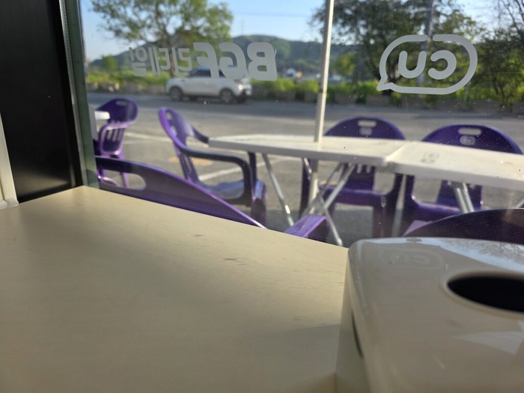 south-korea-convenience-stores-outdoor-seating Purple plastic chairs and white tables set up outside a CU convenience store in South Korea.