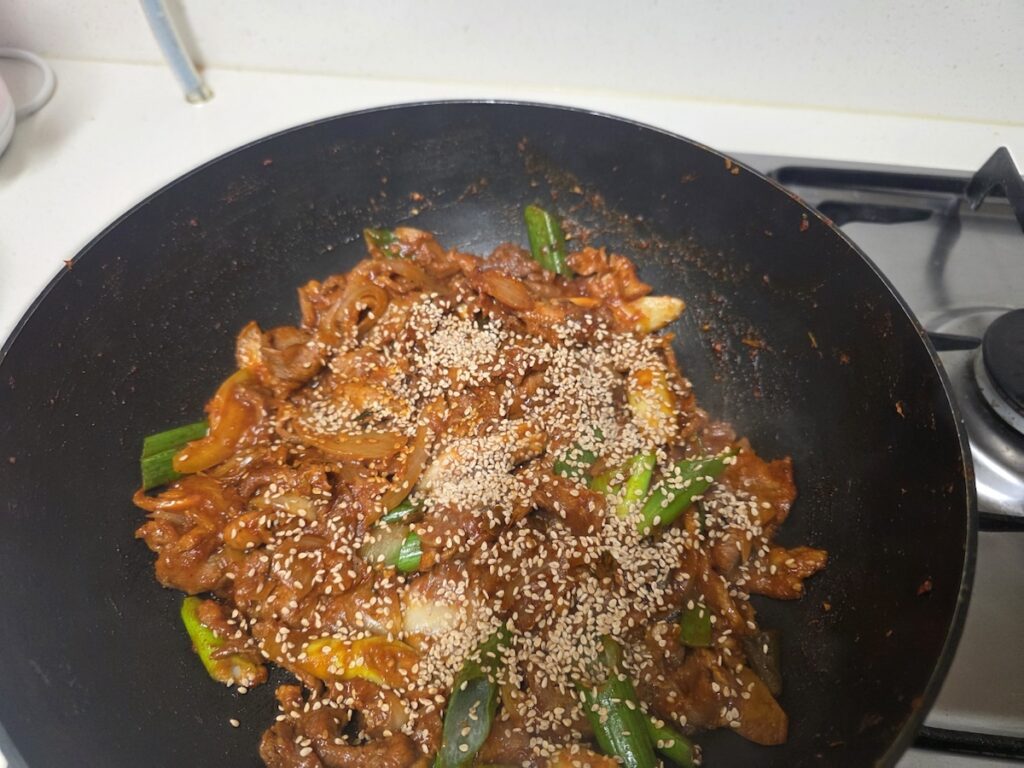 spicy-pork-jeyuk-bokkeum A delicious plate of Jeyuk-bokkeum (Korean spicy pork) garnished with sesame seeds, a popular filling for Ssam.