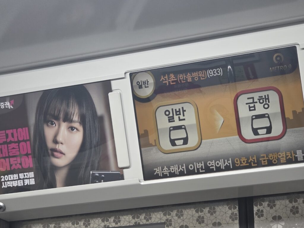 Close-up of Express and Local icons on a Seoul subway train advertisement panel.
