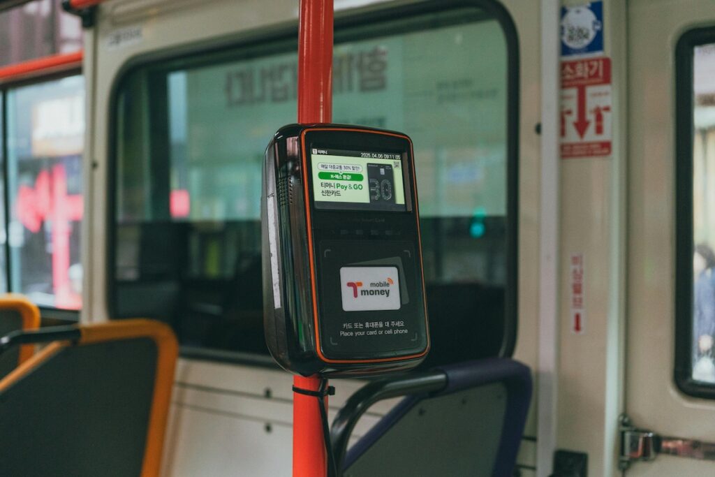 “Traveler tapping a T-money card on a Seoul bus reader.”