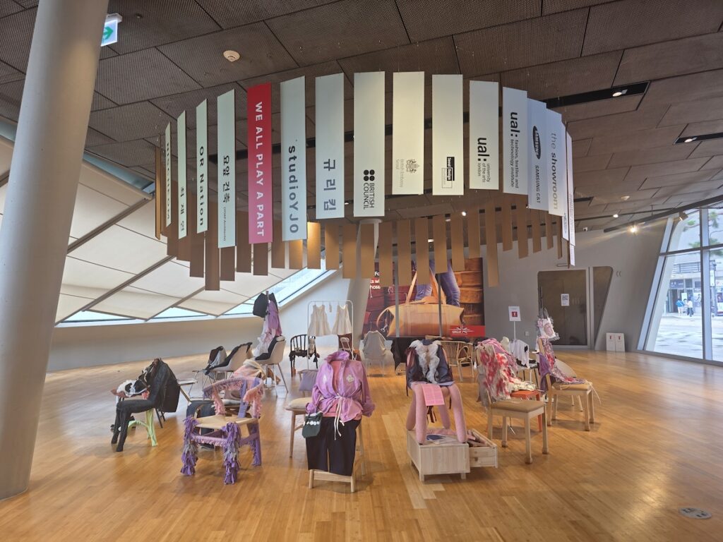 UK Korea Fashion Futures DDP showroom with partner banners and upcycled chair installations