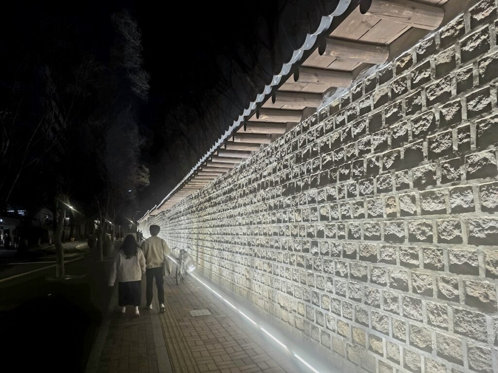 why-koreans-avoid-bothering-others-seoul People quietly walking along Deoksugung Stone Wall Road in Seoul, reflecting why Koreans are so quiet in public spaces