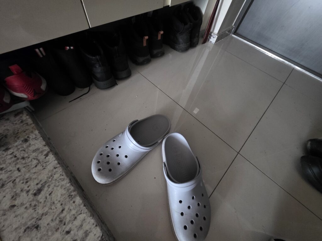Shoes left at the entrance of a Korean home with indoor slippers, showing why Koreans don’t wear shoes indoors