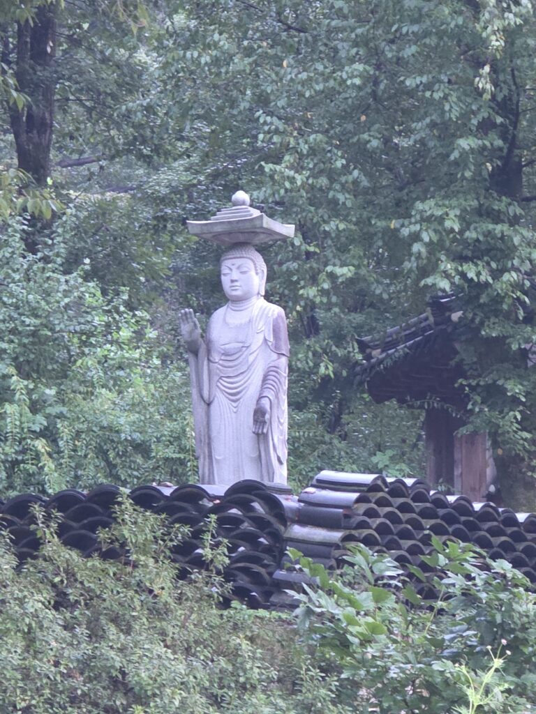 yongmunsa-buddhist-lanterns-decor “Buddha statue at Yongmunsa Temple with traditional Korean Buddhist details”
